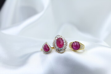 High jewelry banner with color natural gemstone and diamonds on gold ring setting. White satin background with golden tray for jewelry shop