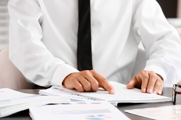 Businessman working with documents at desk in office, closeup