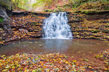 Beautiful small waterfall on a mountain stream. Beautiful autumn landscape