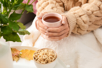 Obraz na płótnie Canvas Woman with cup of hot tea at home on autumn day, closeup