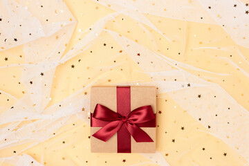 Obraz premium Gift box with red ribbon on a golden background. Festive concept.