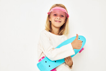 Portrait of young smiling kid pink cap with skateboard lifestyle childhood
