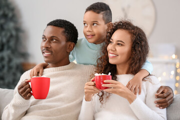 Obraz premium Happy African-American family drinking tasty hot chocolate at home on Christmas eve