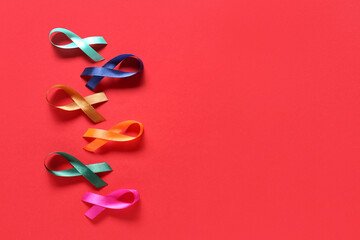 Different awareness ribbons on red background. World Cancer Day