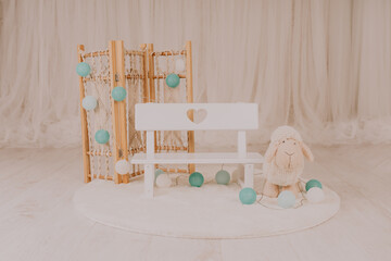 Mini bench with a sheep for a baby photo session in a photo studio