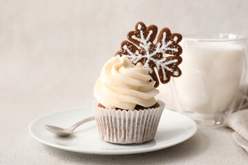 Plate of tasty Christmas cupcake with gingerbread cookie on light background