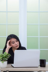 Business woman sitting on chair looking at laptop screen with confused expression