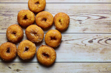 Sweet, sugar rings on light-colored rustic wooden boards. Zenith view and copy space.