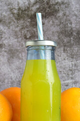 Vertical shot, close up, glass bottle with refreshing orangeade.