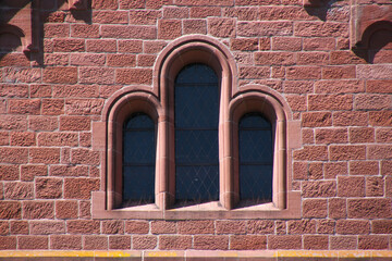 Choir window with round arches on a red sandstone facade at the romanesque monastery church in Enkenbach near Kaiserslautern, Pfalz region in Germany