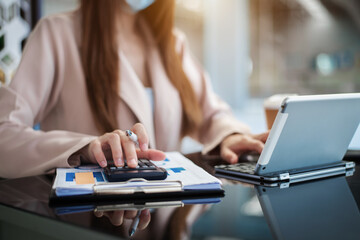 Hand women doing finances and calculate on desk about cost at home office.