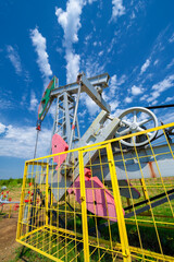 Fototapeta na wymiar A pumpjack is the overground drive for a reciprocating piston pump in an oil well. The arrangement is commonly used for onshore wells producing little oil. Pumpjacks are common in oil-rich areas.