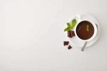 Background cup with liquid chocolate with mint on white table © Davizro Photography