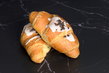 deux croissants au beurre sur fond marbré