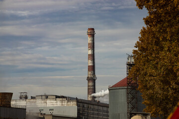 Fototapeta na wymiar Industrial building with chimneys near the road in autumn