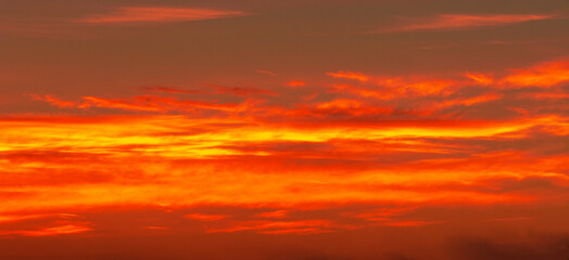 Naklejka na ściany i meble Photo of the sky with clouds, sunrises, sunsets, orange-yellow tones from the setting sun