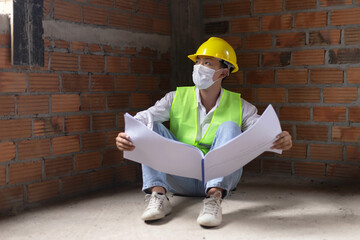 engineer concept The male building maker in full protecting outfits perching on the ground of the...