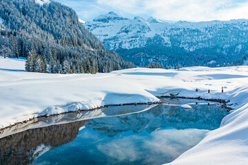 Les montagnes enneigées se reflètent magnifiquement dans les eaux claires de ce tarn dans la région de Gnadealm Obertauern, Autriche