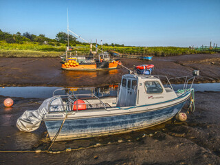 Fototapeta premium Small fishing boats moored in the Stone Creek inlet at Sunk Island, East Yorkshire, UK
