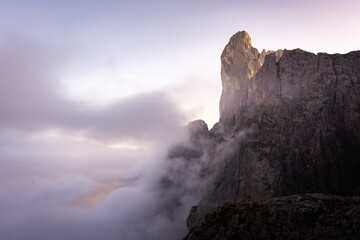 edge of a cliff in the mountains of pale di san martino in the dolomites surrounded by clouds