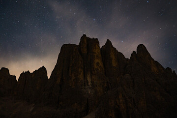 starry night over mountain peaks in the dolomites alps at night