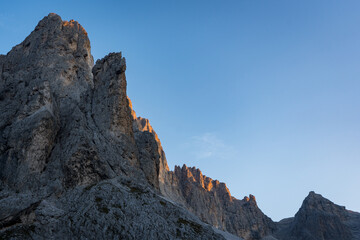 sun touching the mountains of pale di san martino in the dolomites alps
