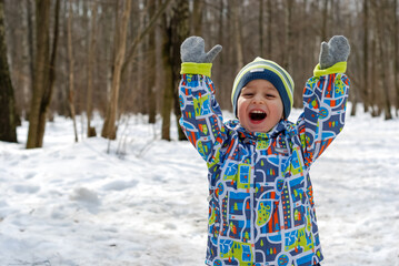 Smiling boy on the background of a snowy forest