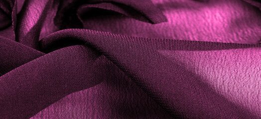 Texture. Background red burgundy silk fabric, top view. Smooth elegant texture of red silk or satin can be used as an abstract background with copy space.