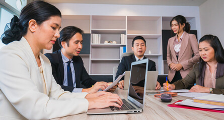 young women worker using computer while working with team