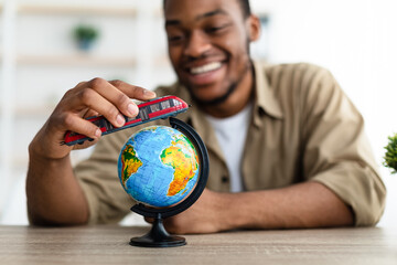 African Man Playing With Train Model And World Globe Indoors