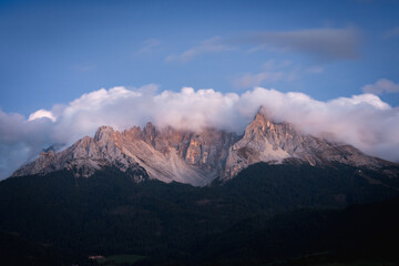 clouds over dolomites mountains latemar early in the morning