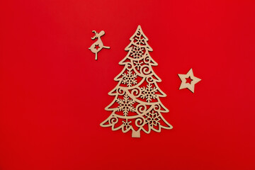Fototapeta na wymiar wooden decorative decoration of fir-tree, star and deer on red background