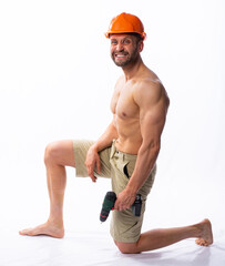 a muscular man in shorts and a construction helmet holding a tool - a screwdriver. worker repairing something. isolated, white background