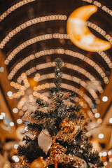 Christmas tree decorated with golden festive toys and ornaments. Magic New Year details, gold bokeh...