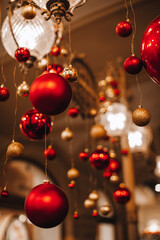 Christmas shiny golden red Christmas balls with glitter hanging in the festive interior. New Year details and magic atmosphere