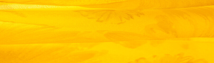 Background texture, yellow silk fabric with painted meadow flowers, colors between green and orange...
