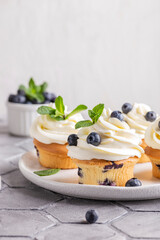 Blueberry cupcakes decorated with vanilla cream