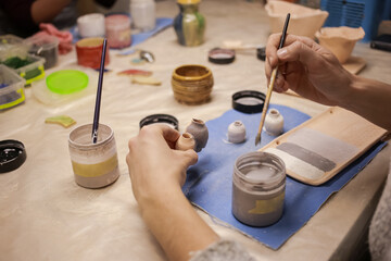 A human sculptor makes a clay product with his own hands