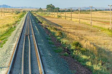 Fototapeta na wymiar railway, railroad, rail, elevated. steppe prairie veld. is a means of transportation and passengers of trucks moving on rails that are located on the rails of the Great Plains. The steppe is great.