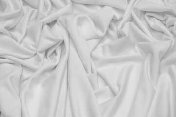 White silk fabric. Texture. Background. Pattern. Dupioni silk fabric has a shiny sheen and characteristic small folds that run horizontally. She lies down in soft folds