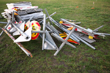 Temporary road signs lie on the grass.