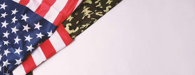 Fototapeta na wymiar American flag and Military camouflage pattern. Top view angle. Soldier flag with national American flag on white background. Represent military concept by camouflage fabric and USA national flag.