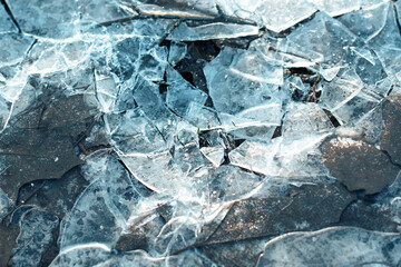 Сlose-up of a frozen ice formations on the water surface. Natural winter texture. Small frozen puddle
