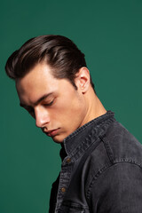 Fototapeta premium Close-up portrait of young handsome young man, student isolated on dark green studio background. Natural beauty