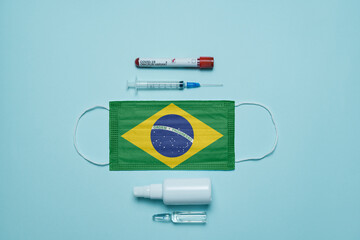 Blood tube for test detection of virus Covid-19 Omicron Variant with positive result, medicine mask with Brazil flag superimposed and vaccine.  New Variant of the Covid-19 Omicron - 476739963