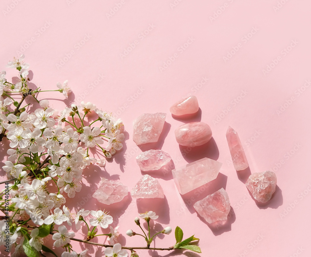 Wall mural Rose quartz minerals set and white flowers on pink background. gemstones for esoteric spiritual relax practice, Magic Crystal Ritual, Witchcraft, open Chakra. Feng Shui, reiki therapy. flat lay