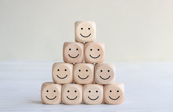 image of wooden blocks with smiling faces icons over table ,building a strong team, human resources and management concept.