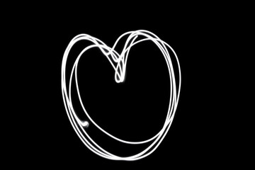 Fototapeta na wymiar heart shape expressed in white light on a dark night.