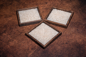 Fototapeta premium Some square containers of white rice in the dark background
