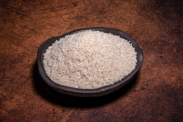 The white rice in the bowl is on the dark background